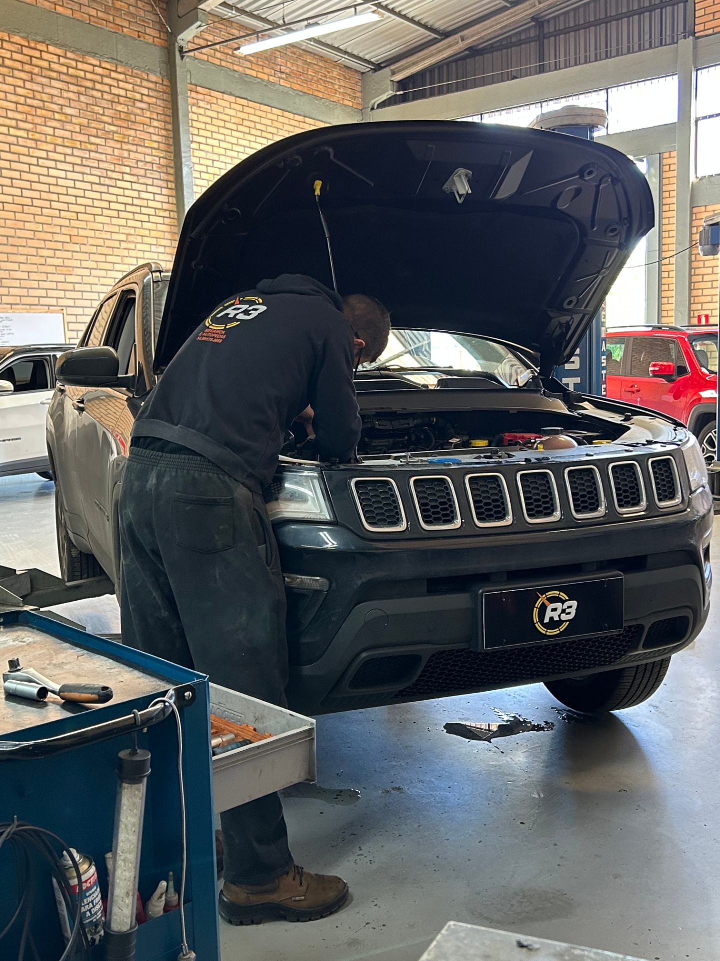 Mecânico da R3 atendendo um Jeep na oficina